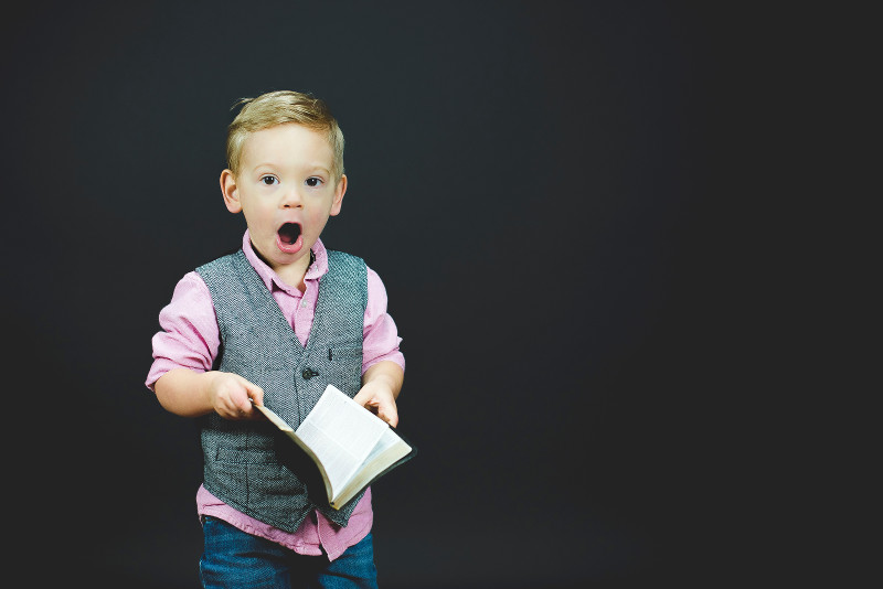 Kind das Staunt und Buch in der Hand hält von Ben White (unsplash)
